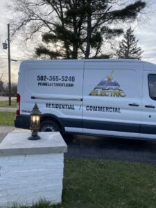 A Peak Electric service van parked near an outdoor light fixture in Mount Washington, KY, indicating residential electrical services.