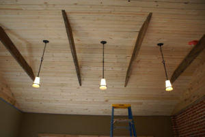 Pendant light installation on a wooden ceiling, indicating electrical work by Accuracy Electric Incorporation in Lakewood, CO.