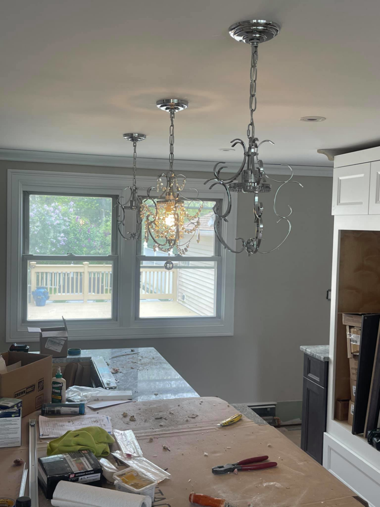 Installing decorative pendant lights over a kitchen island by A.C. & Son's Electric LLC in Pawtucket, RI