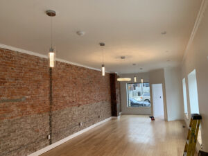 A room with exposed brick and new pendant and recessed lighting installed by Moss Contracting in Philadelphia, PA.