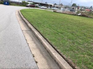 A perfectly edged commercial lawn along a curb, showcasing precise lawn care services by Lande Lawn Care in Broken Arrow, OK.