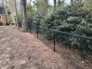 A perimeter black chain-link fence installed around a property by Almaraz & Sons LLC in Macon, GA.