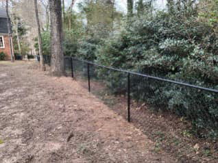 A perimeter black chain-link fence installed around a property by Almaraz & Sons LLC in Macon, GA.