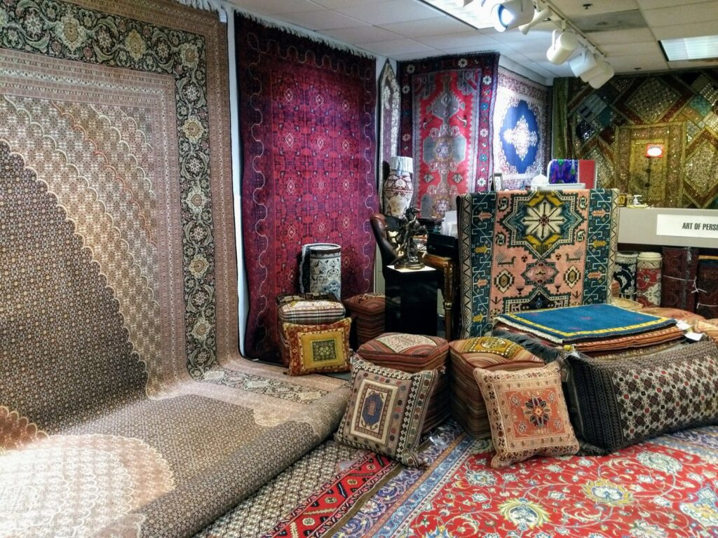 A vibrant display of Persian rugs and decorative cushions in the Art Of Persia showroom in Portland, OR.