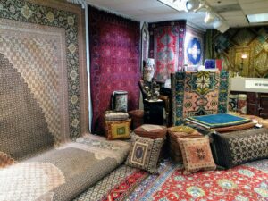 A vibrant display of Persian rugs and decorative cushions in the Art Of Persia showroom in Portland, OR.