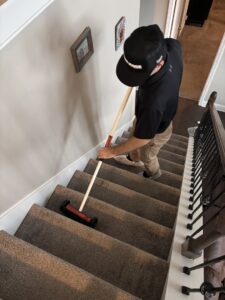 A professional using a specialized tool to clean carpeted stairs, showcasing carpet contractor services by Pro Clean Group in Knoxville, TN.