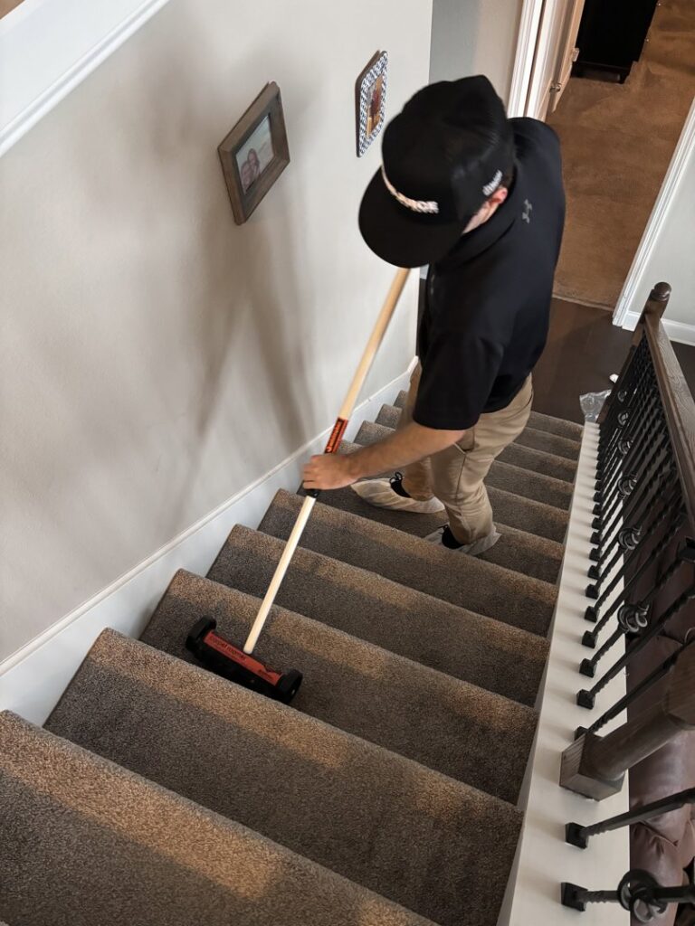 A professional using a specialized tool to clean carpeted stairs, showcasing carpet contractor services by Pro Clean Group in Knoxville, TN.