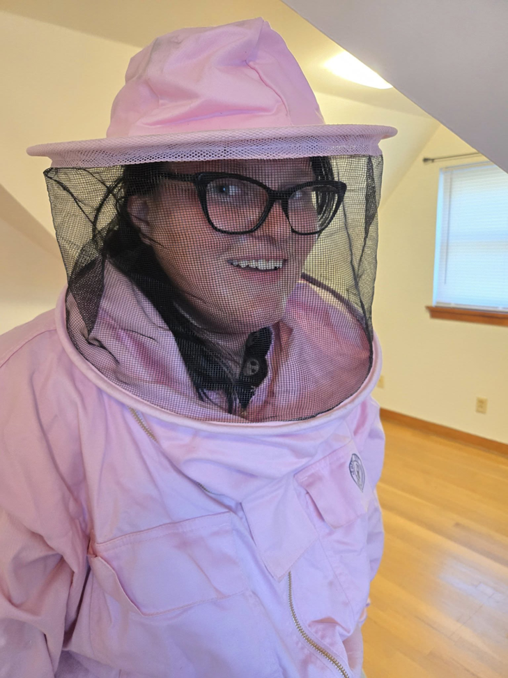 A person wearing a pink beekeeper suit and veil, ready for a pest control job at Stryker Pest Control LLC in Columbus, OH.