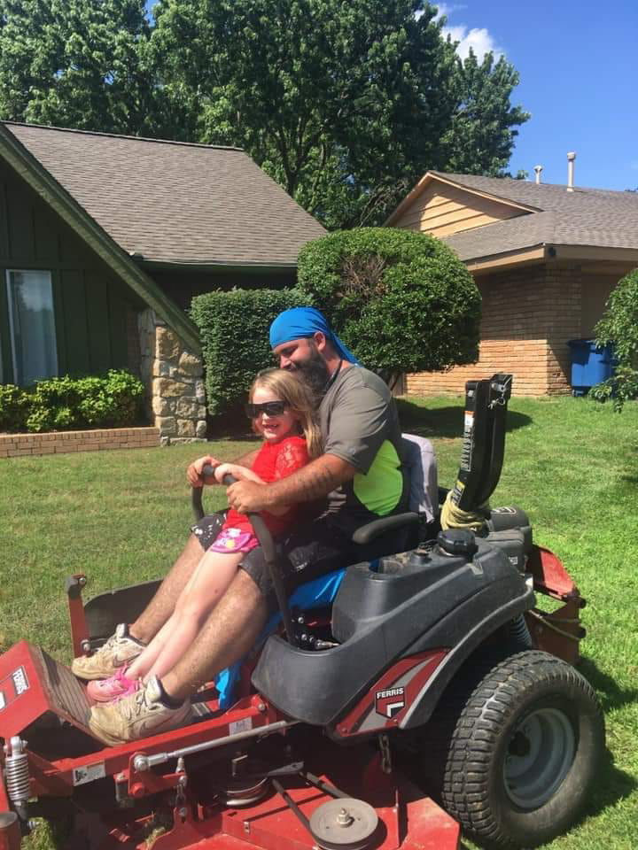 A person operating a riding lawn mower, demonstrating professional lawn care services by K&R Lawn Care in Pass Christian, MS.
