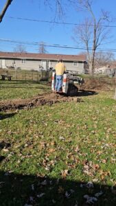A person operating a skid steer to move earth for a landscaping project by ALL Lawn Care Service in Saint Louis, MO