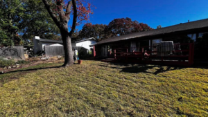 A person raking leaves in a backyard, a service provided by GAMAS Lawn Care Services in Tulsa, OK.