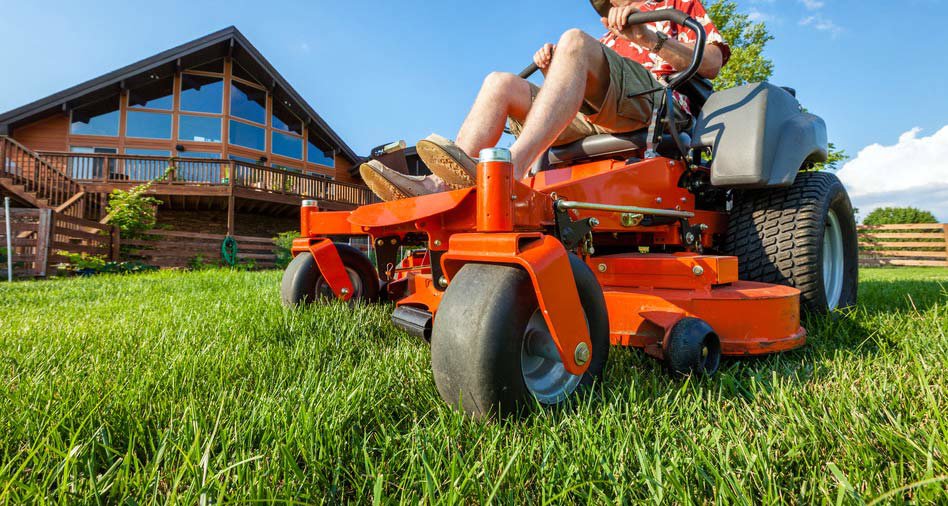 A person riding a zero-turn lawn mower to cut grass for Aaron's Lawn Service in Pittsburg, KS.