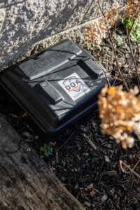 An outdoor pest bait station placed near a house by DOA Pest Service in Nashville, TN.