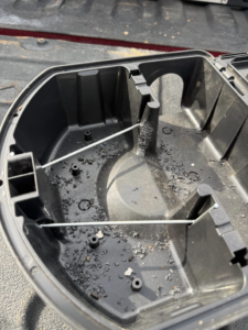 An open pest bait station showing debris, indicating rodent or insect activity, used by Blue Line Pest Police in Fort Worth, TX.