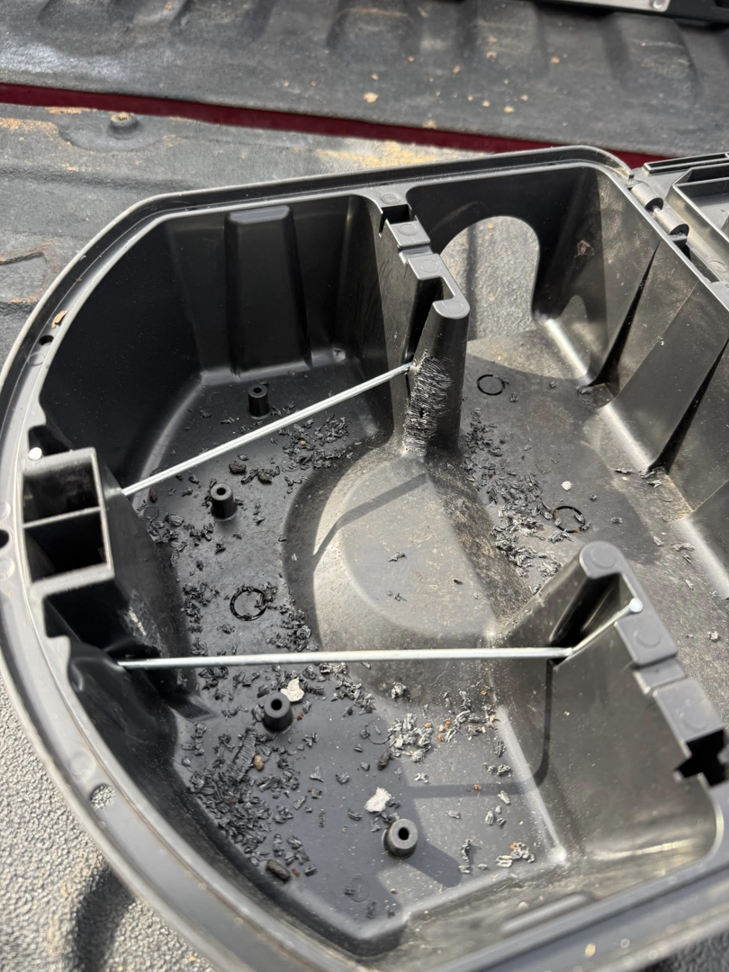 An open pest bait station showing debris, indicating rodent or insect activity, used by Blue Line Pest Police in Fort Worth, TX.