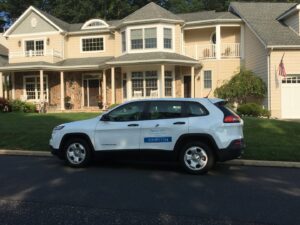 A white Pest by MD service vehicle parked in front of a residential home in Jersey City, NJ.