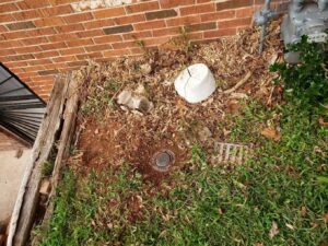 A pest control bait station installed next to a brick house by Absolute Exterminating Services in Ellenwood, GA.