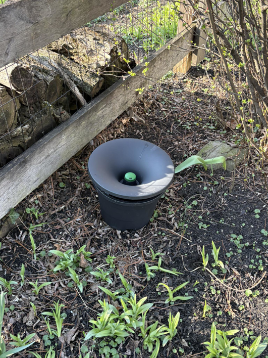 A pest control bait station installed in a garden by Complete Termite & Pest Control in Mason, OH.