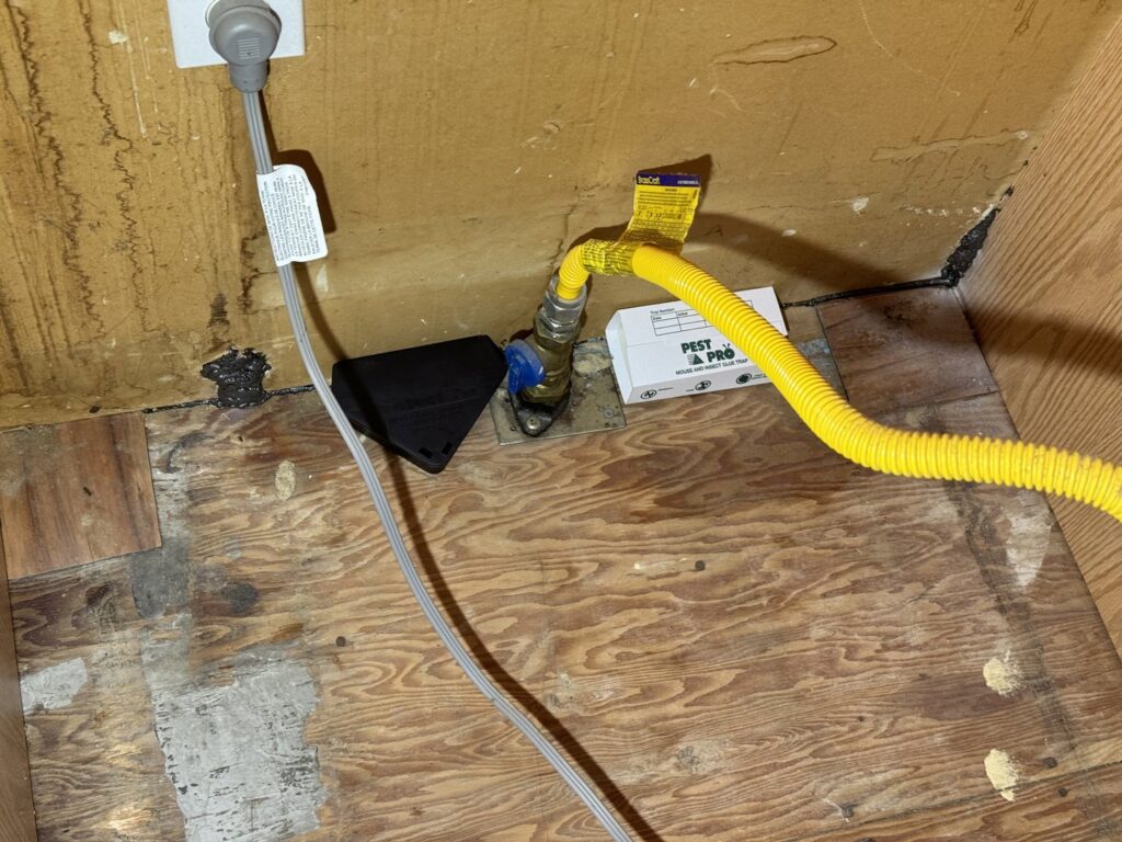 A pest control bait station placed under a sink, part of a rodent treatment plan by Charm City Pest Control Solutions LLC in Baltimore, MD.