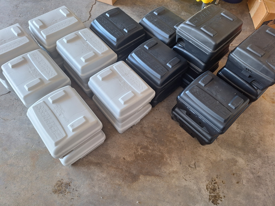 Stacks of black and white pest control bait stations used by Howe Pest Management in Manhattan, KS, for effective pest management.