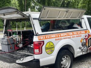 Pest control equipment, including tanks and hoses, visible in the open truck bed of El Exterminador Del DMV in Rockville, MD.