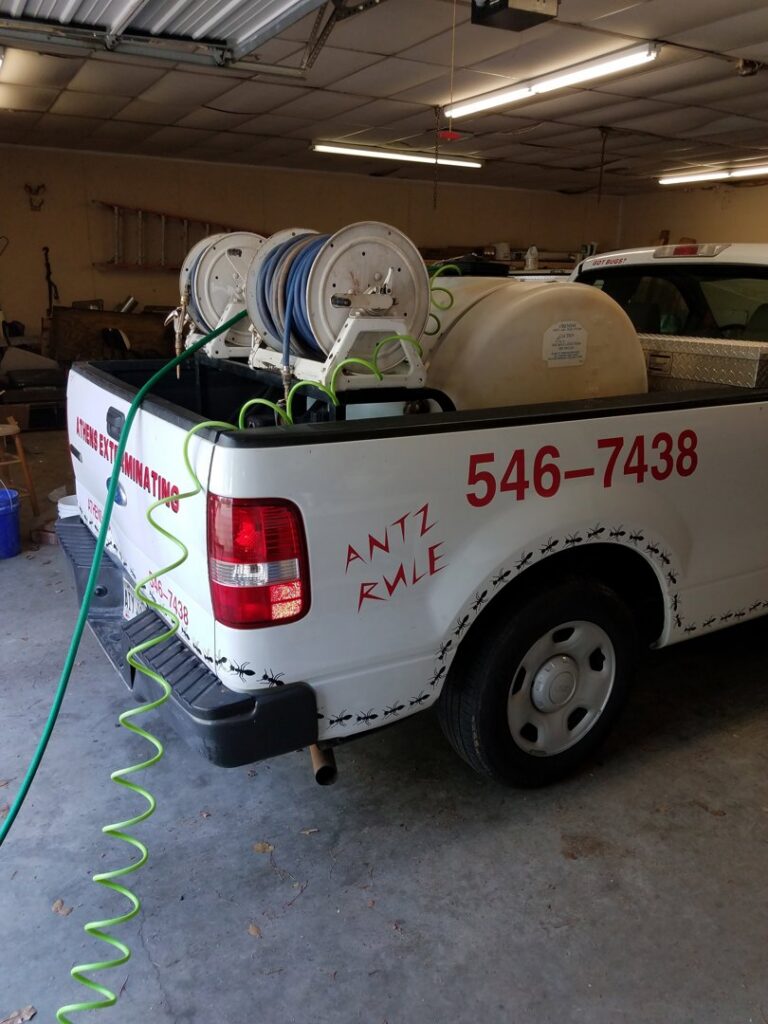Pest control equipment including hoses and a tank in the back of an Athens Exterminating Inc. truck in Athens, GA