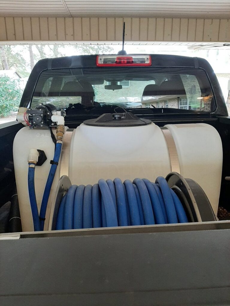 Pest control equipment, including a large tank and hose reel, in the back of a service truck for S&L Pest Services, LLC in New Orleans, LA.