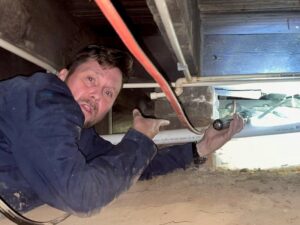 A PestNation pest control expert working in a residential crawl space in Buford, GA
