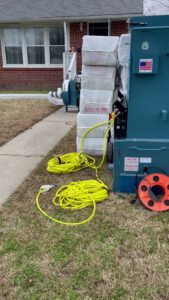 Pest control insulation equipment set up outside a residential home by Global Green Termite & Pest Control LLC in Hampton, VA.