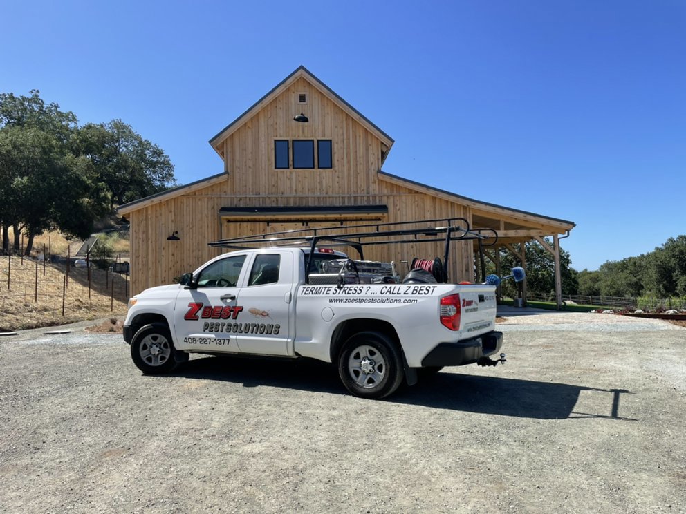A Z Best Pest Solutions service truck parked in front of a wooden barn, ready for a pest control job in San Jose, CA.