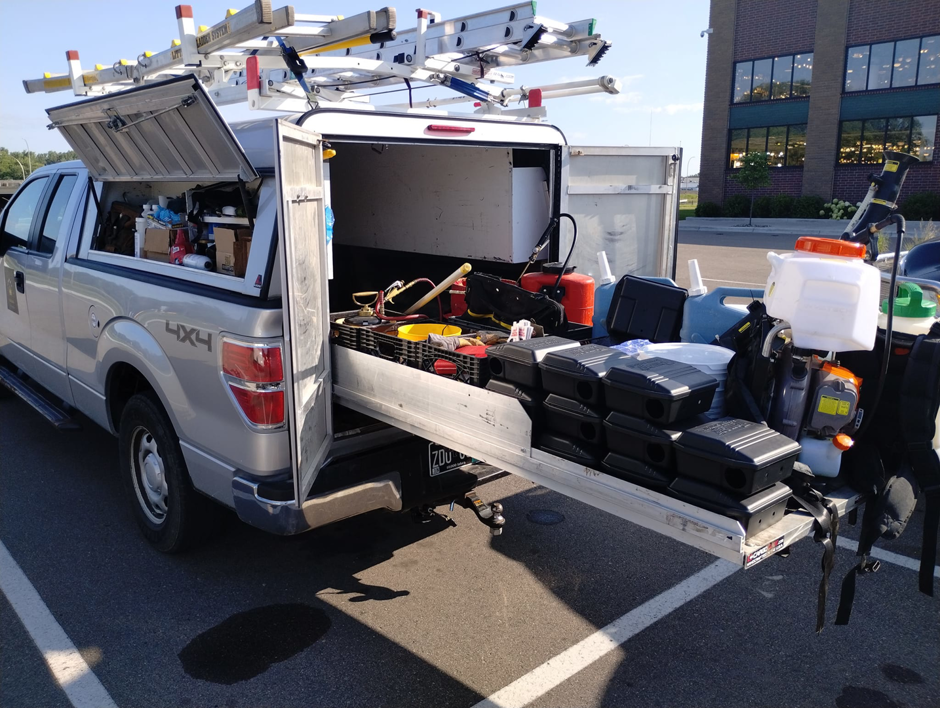 A Kingdom Pest Control & Services truck in Brooklyn Park, MN, loaded with equipment for a wildlife and pest control job.