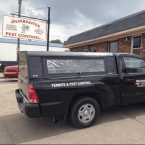 A black pest control service truck for Guarantee Pest Control, Inc. in Lexington, KY, ready for termite and pest control jobs.