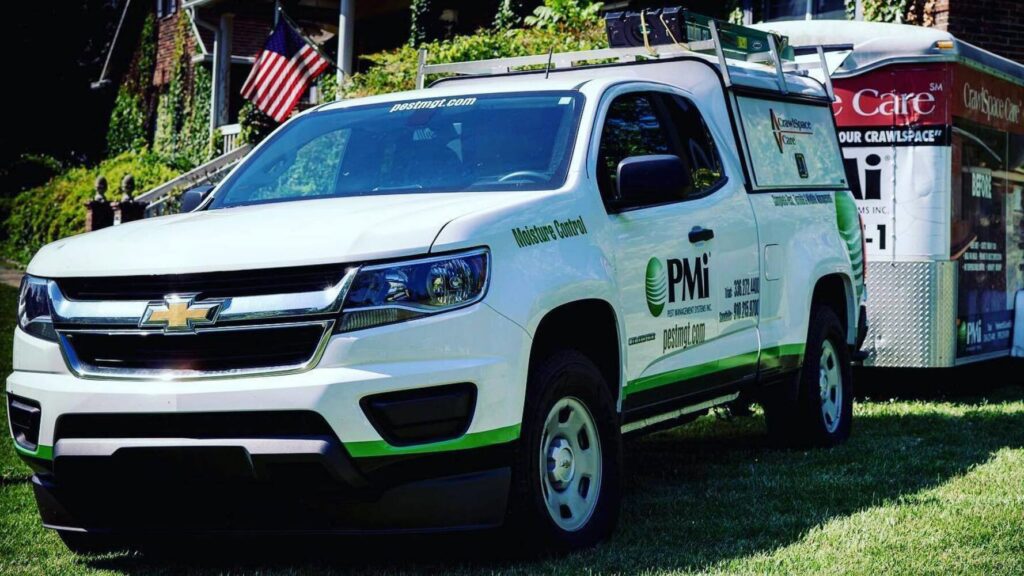 A Pest Management Systems, Inc. service truck and trailer for pest and moisture control in Greensboro, NC