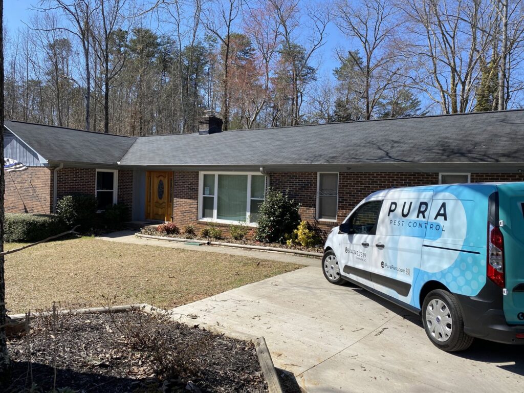 Pura Pest Control service van parked in front of a house in Greenville, SC