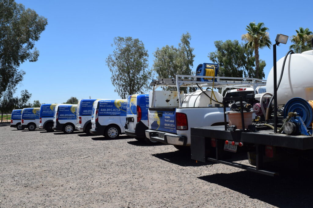 Service vehicles with pest control equipment, including tanks and hoses, for Sun Lakes Pest Control in Chandler, AZ.