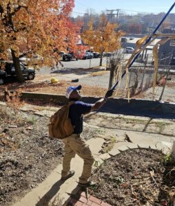 A Blue Beetle Pest Control specialist treating a high-up area of a property for pests in Kansas City, MO.