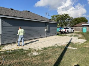 A Solutions Pest Management specialist treating the perimeter of a house for pest control in Corpus Christi, TX.