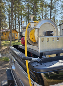 Close-up of pest control spray equipment with a hose reel in a BugMeisters North truck in Lindstrom, MN