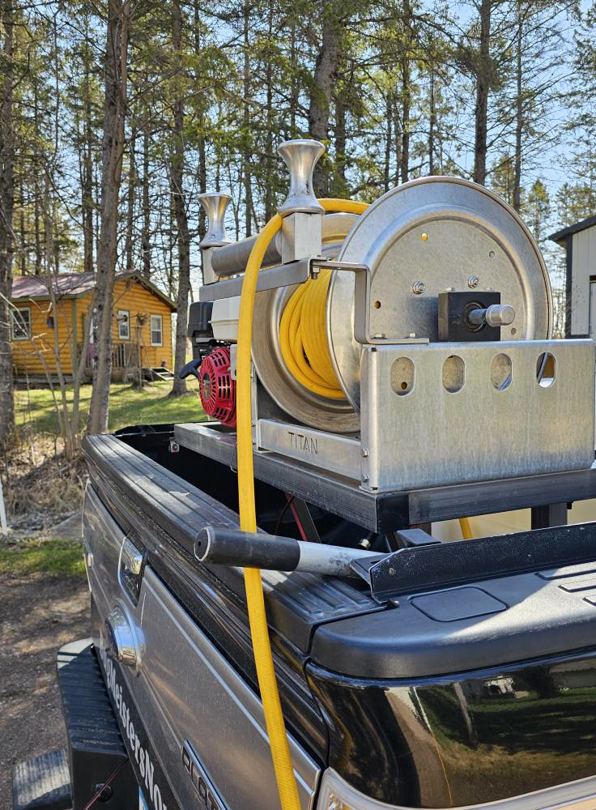 Close-up of pest control spray equipment with a hose reel in a BugMeisters North truck in Lindstrom, MN