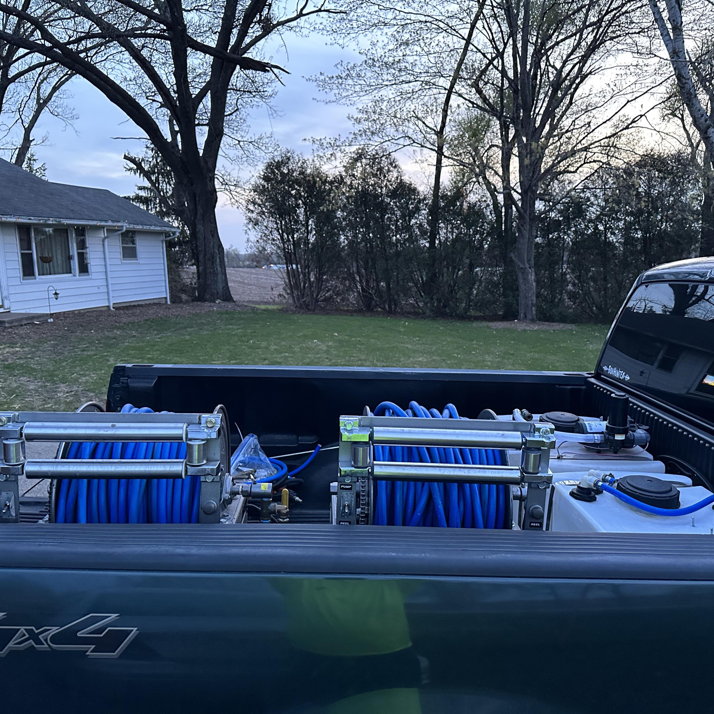 Pest control spray equipment with blue hoses and tanks loaded in a truck bed for Pest Express Pest & Termite Control in Cedar Rapids, IA
