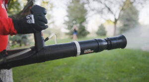 A close-up of a Mosquito Shield pest control sprayer applying treatment to a yard in North Attleboro, MA.
