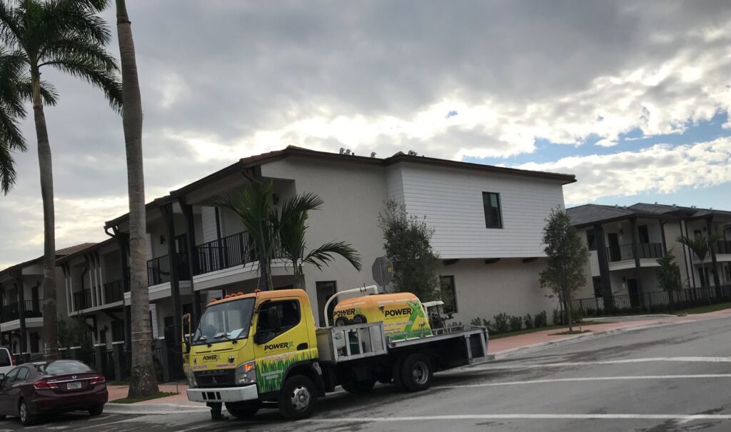 A PowerX Pest Control of South Florida sprayer truck parked in a residential area in Miami, FL.