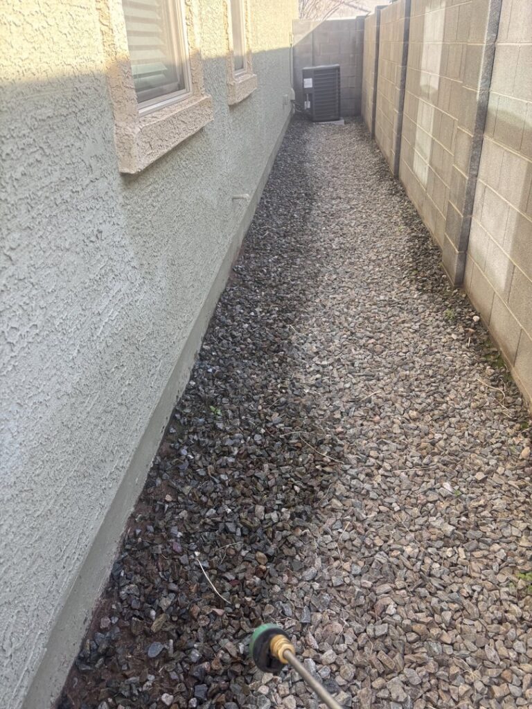 A pest control technician from Sandstorm Pest Control spraying the perimeter of a house in Chandler, AZ.