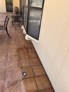 A pest control technician from Sandstorm Pest Control spraying a patio area for pests in Chandler, AZ.