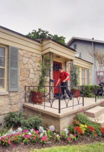A Bug Busters Pest Control technician in uniform arriving at a residential home for a service call in San Antonio, TX.