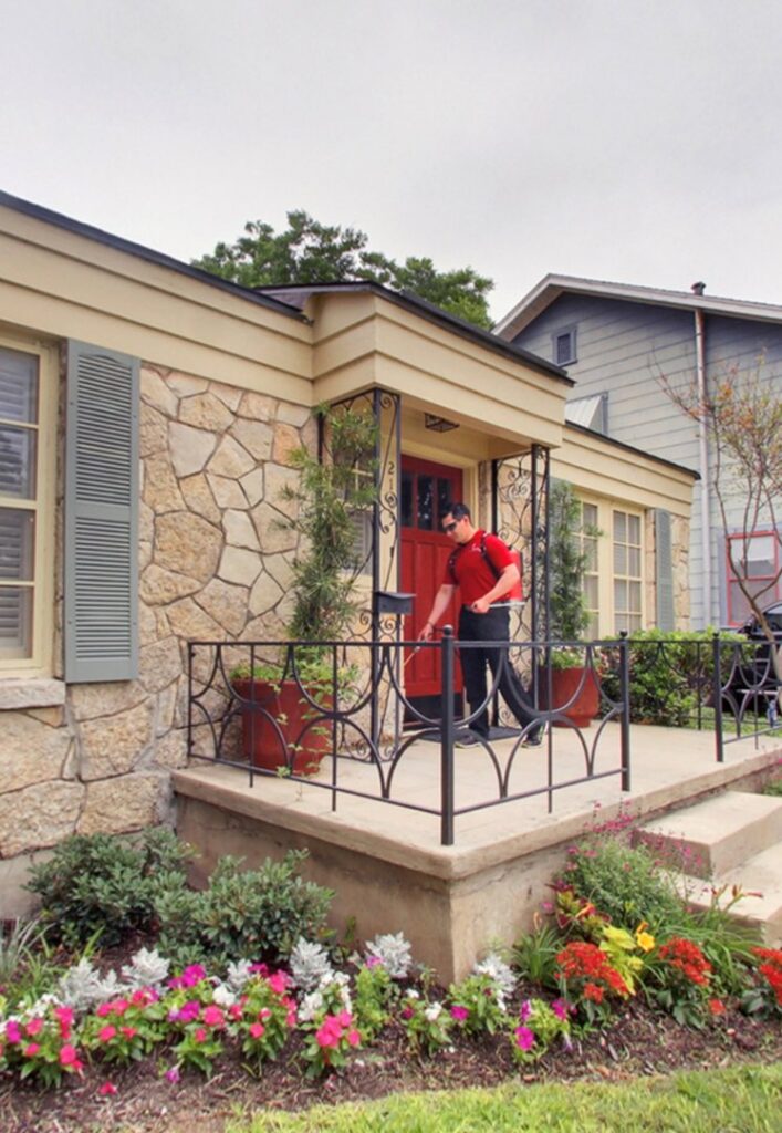 A Bug Busters Pest Control technician in uniform arriving at a residential home for a service call in San Antonio, TX.