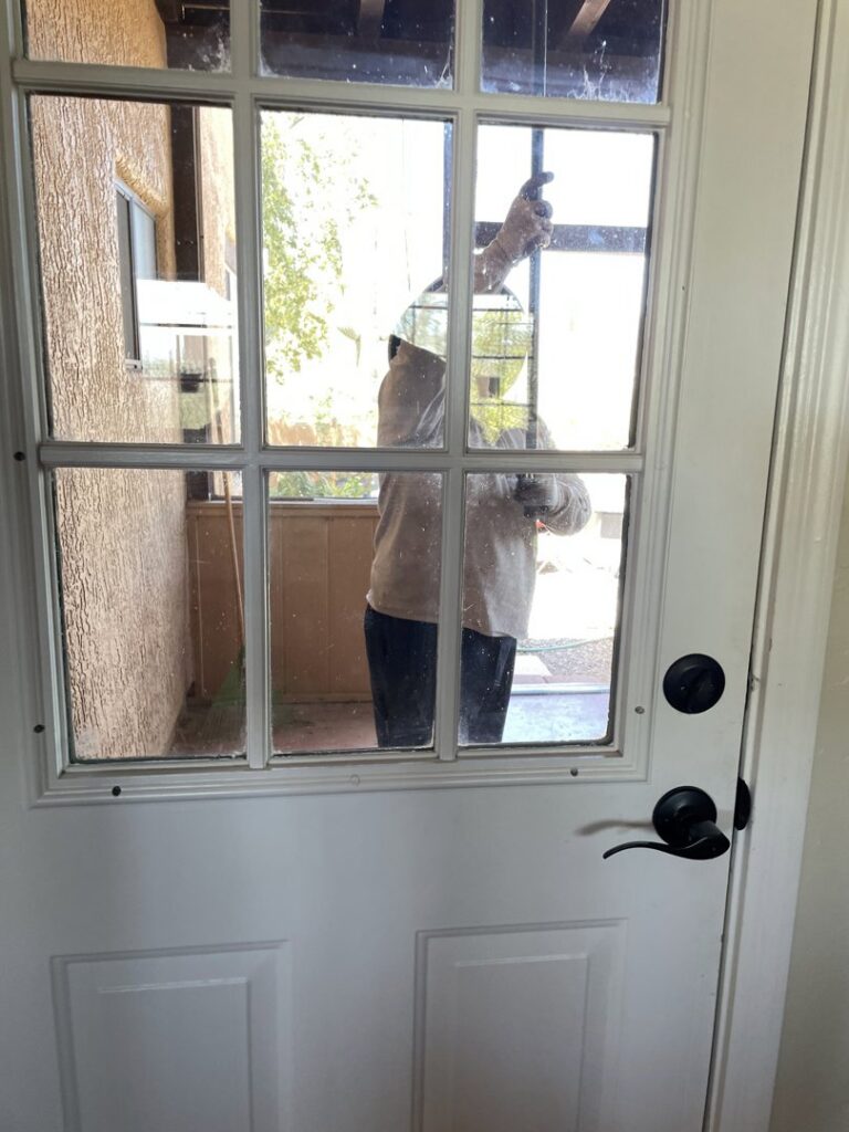 A Termagon Termite & Pest Control technician performing a service at a residential door in Tucson, AZ.