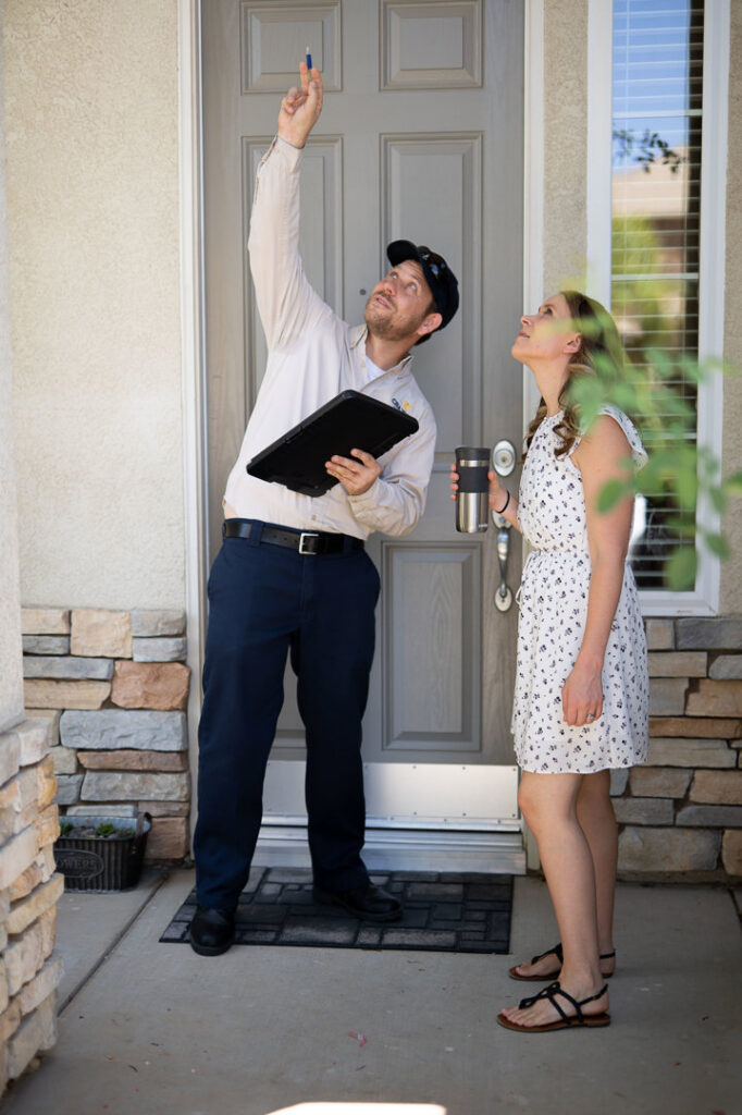A Crazy Ant Pest Control technician consulting with a homeowner at the front door in Fresno, CA.