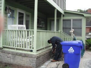 A pest control technician drilling into a foundation for termite treatment by General Pest Solutions in Summerville, SC.