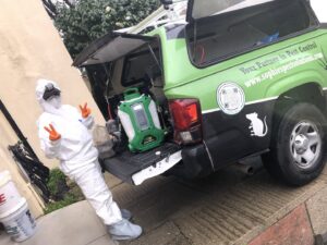 A pest control technician in a hazmat suit with equipment from Sophie's Pest Solutions in Oakland, CA, ready for a job.
